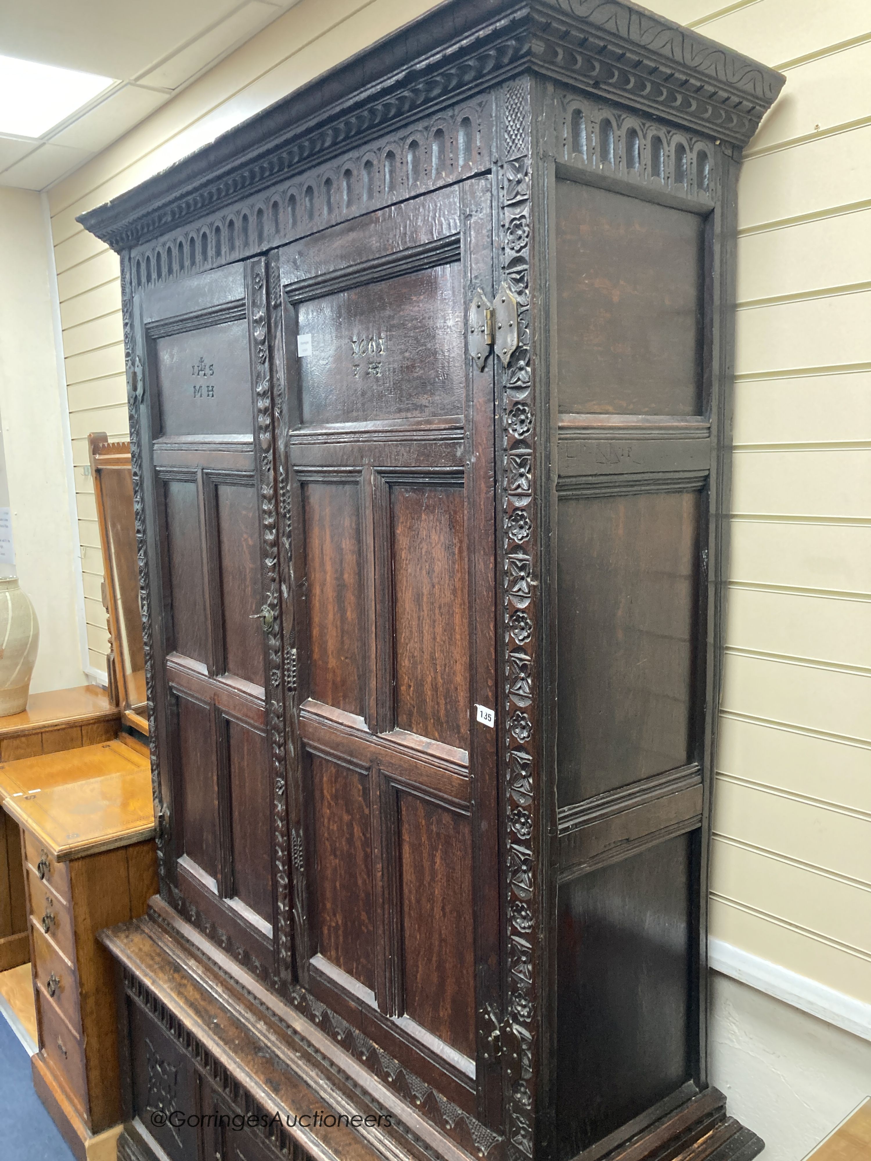 A carved oak cupboard, enclosed by panelled doors, bearing monograms and dated 1601, width 138cm, depth 53cm, height 218cm